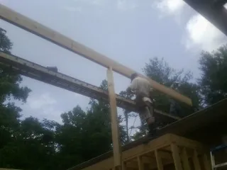 Carpenter setting a ridge beam over a new addition frame — Ice Dam Removal by Roofing Brothers in Norwich
