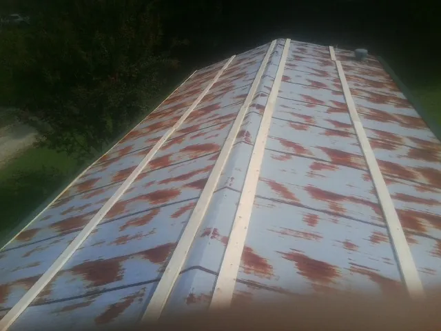 Rusted metal roof panels with new wood purlins before replacement — Storm Damage Roof Repair in Norwich by Roofing Brothers